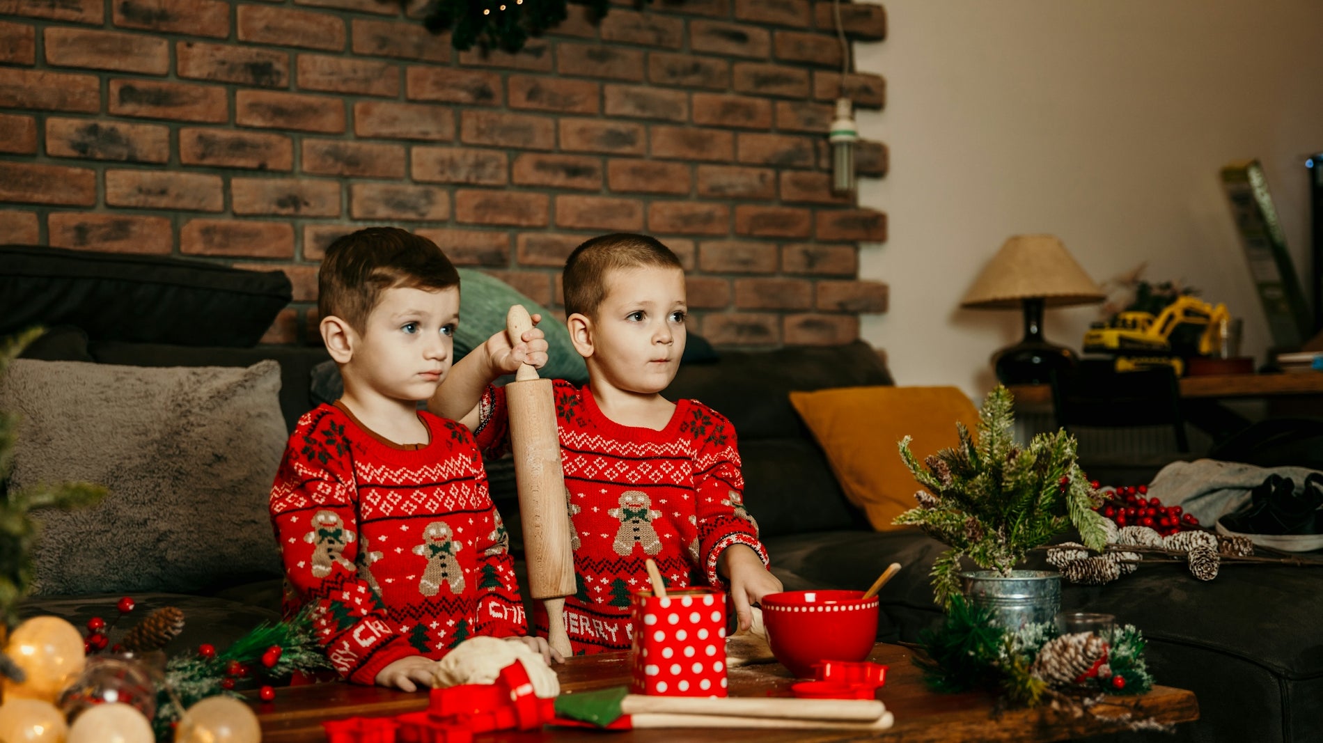 two young boys sitting on a couch in front of a christmas tree