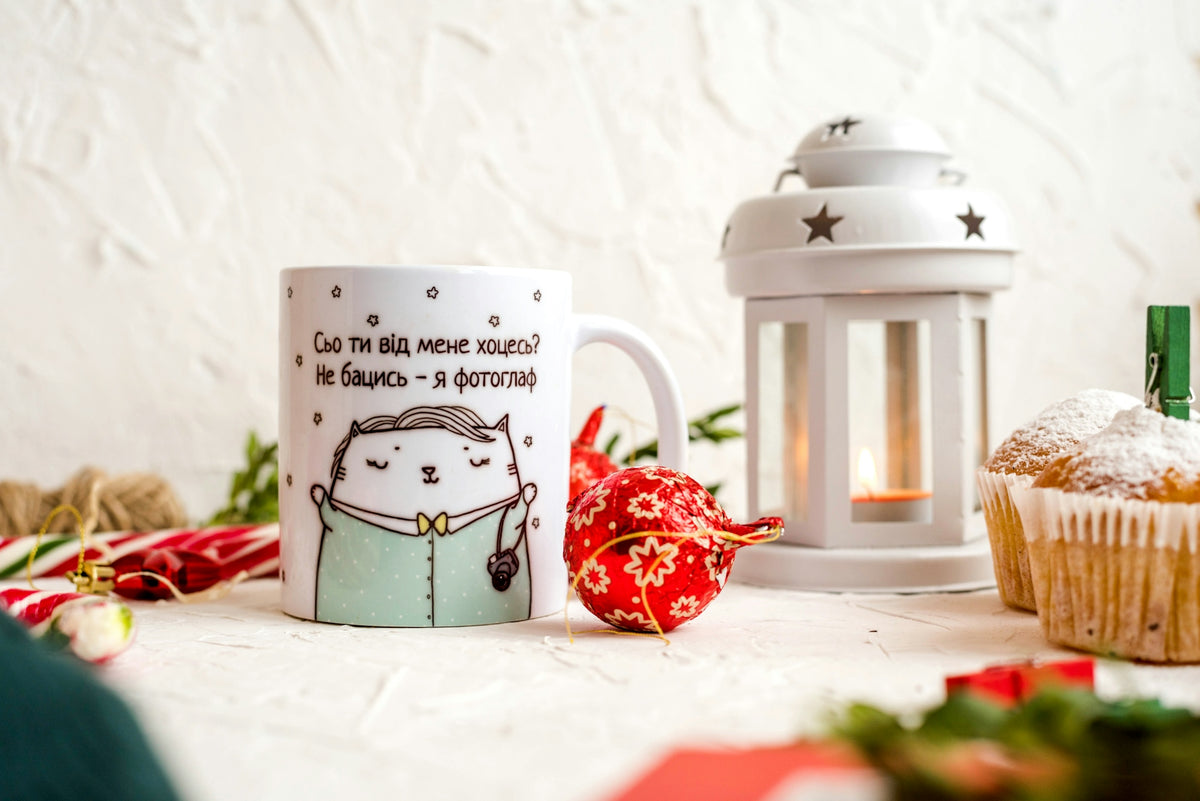 mug near muffins and candle lantern on table