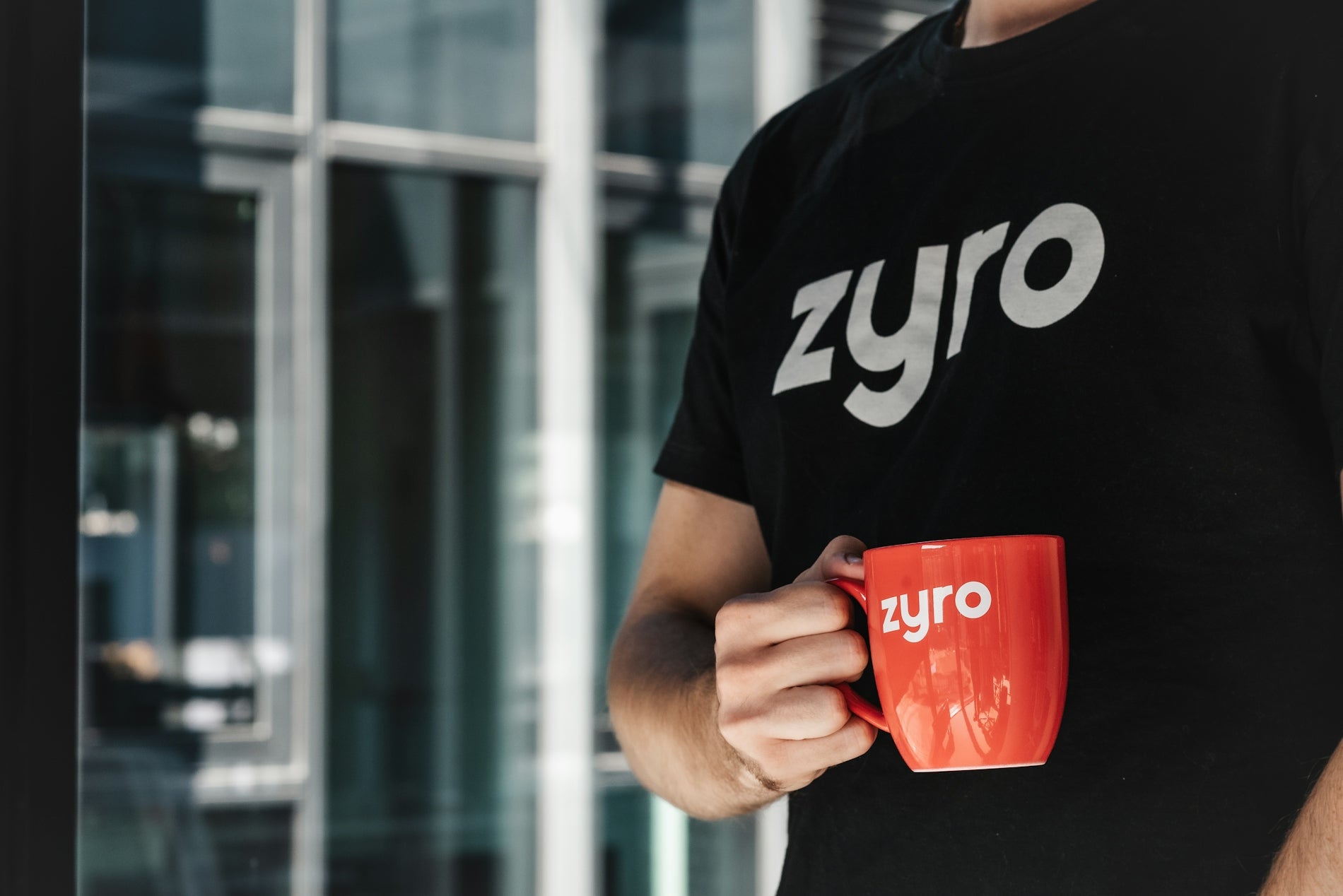 a man is holding a red coffee mug