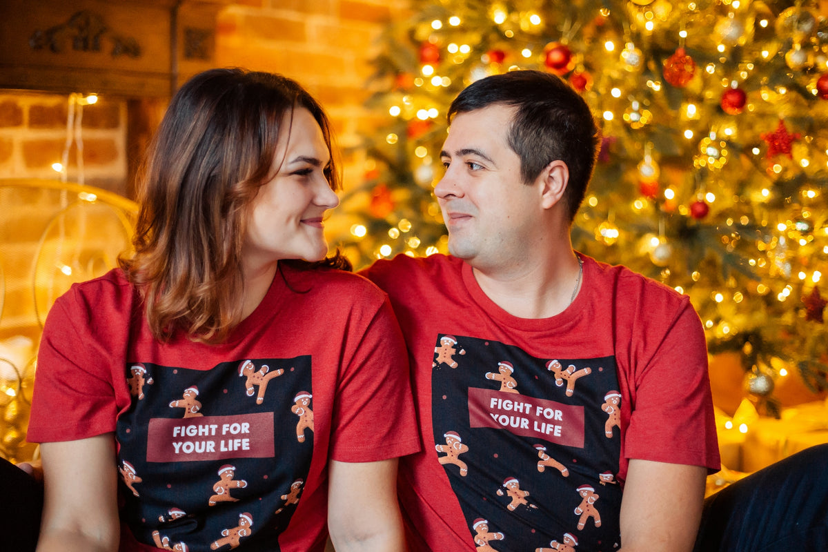 a man and a woman sitting next to each other in front of a christmas tree