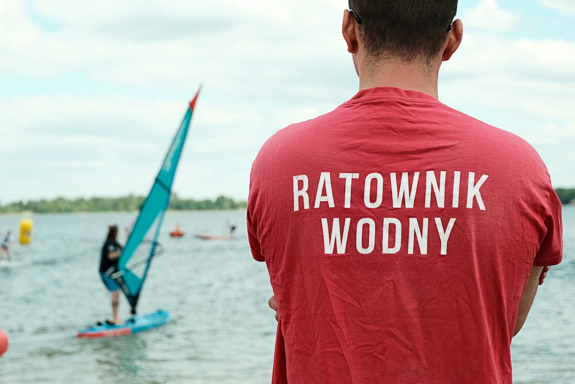 Lifeguard watches windsurfer on the water.